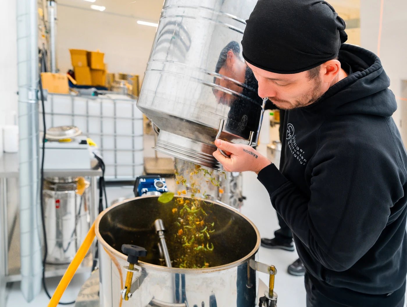 Handwerkliche Herstellung mit Botanicals beim Befüllen der Destille in der Leipziger Spirituosen Manufaktur