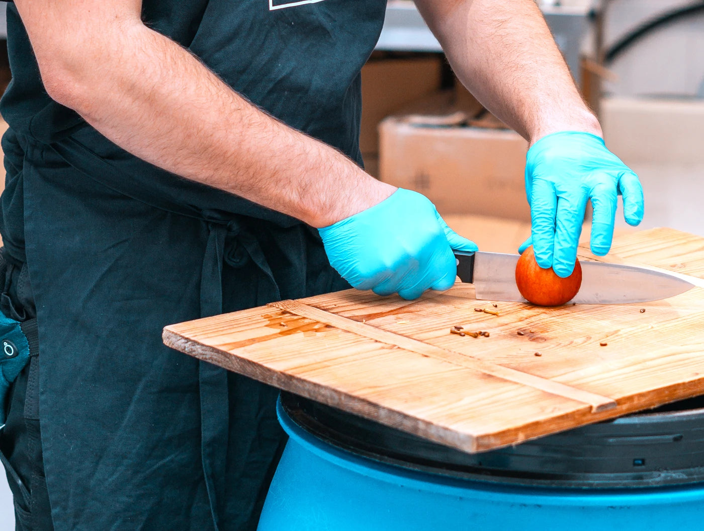 Mitarbeiter schneidet Apfel als natürliche Zutat für handwerkliche Spirituosen in der Leipziger Spirituosen Manufaktur