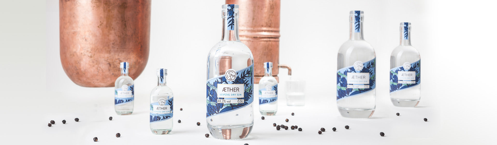 Aether Leipzig Dry Gin Flaschen mit Kupferdestille und Wacholderbeeren
