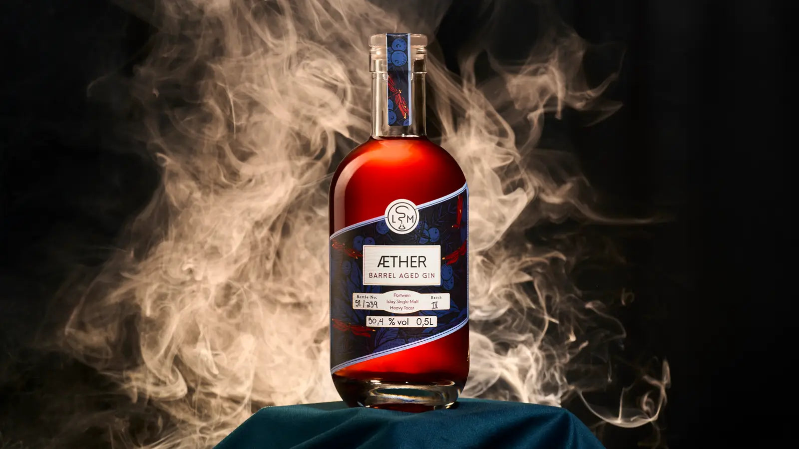 Aether Barrel Aged Gin auf einem Block mit Tuch im Rauch als mystisches Moodbild