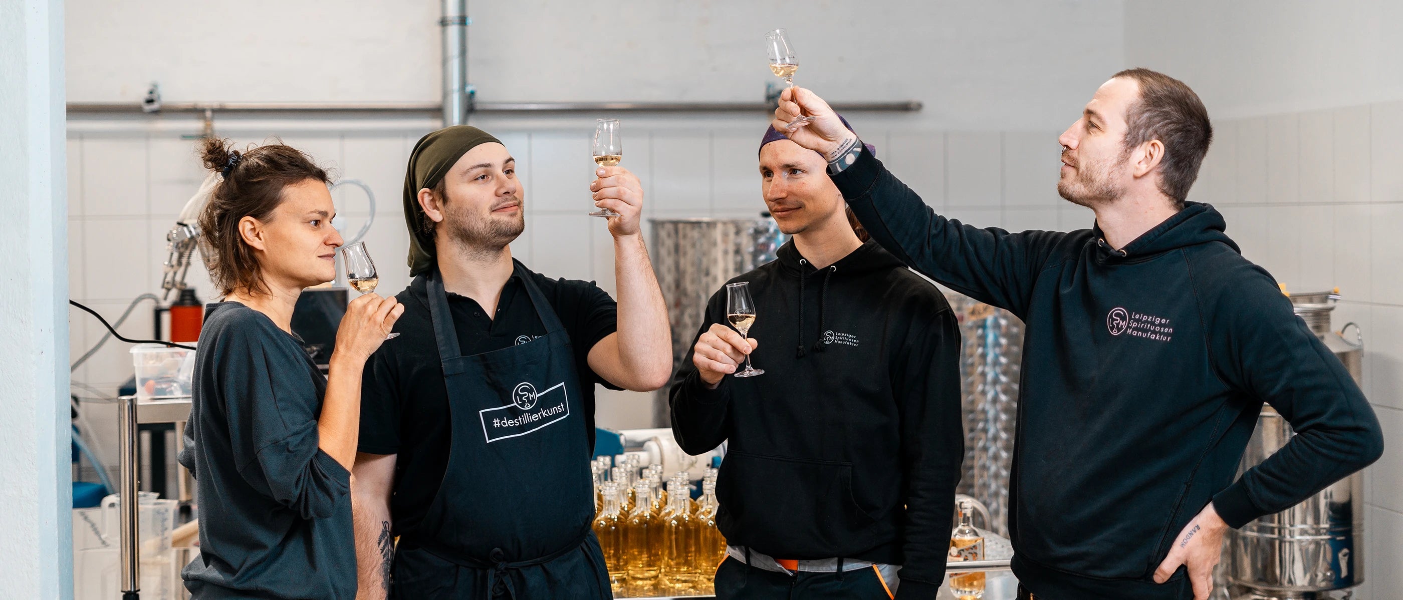 Vier Mitarbeiter des Teams der Leipziger Spirituosen Manufaktur in der Produktion beim Tasting handwerklicher Spirituosen in Leipzig